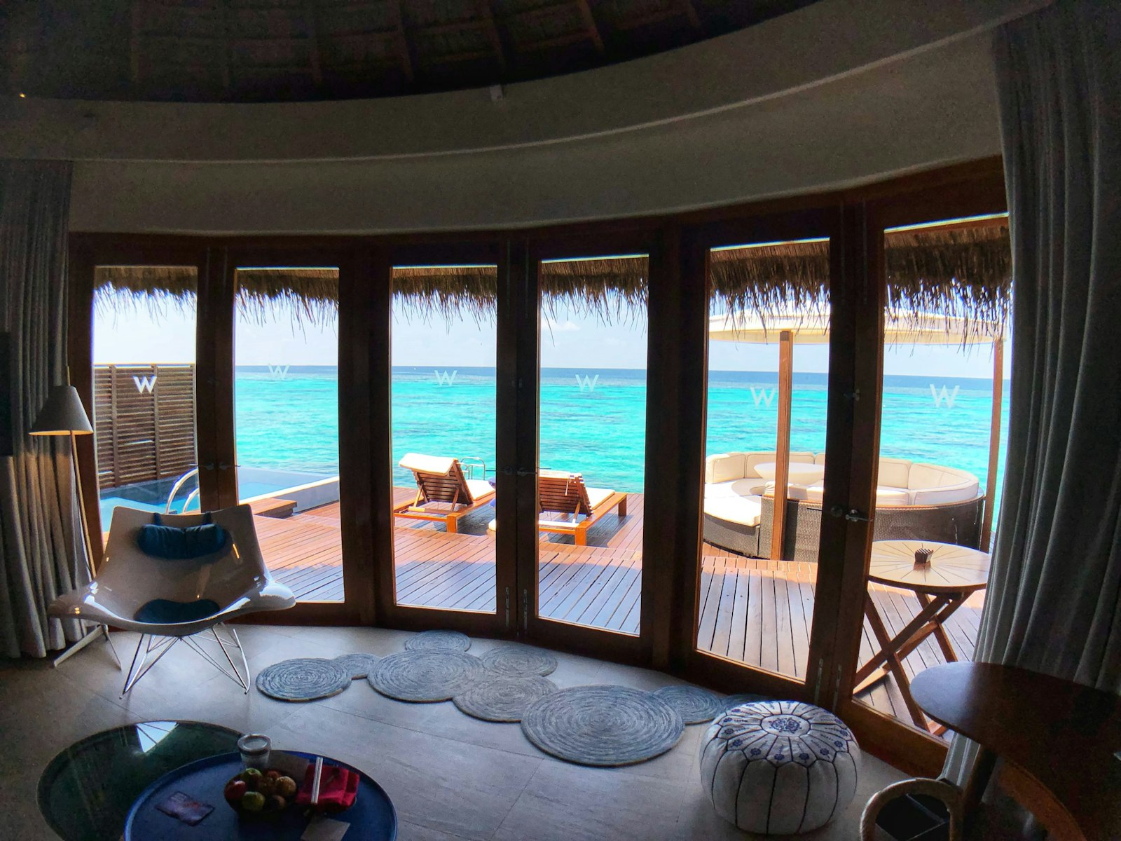 Overwater platform with sun lounger above turquoise water — luxury beach experience Dubai